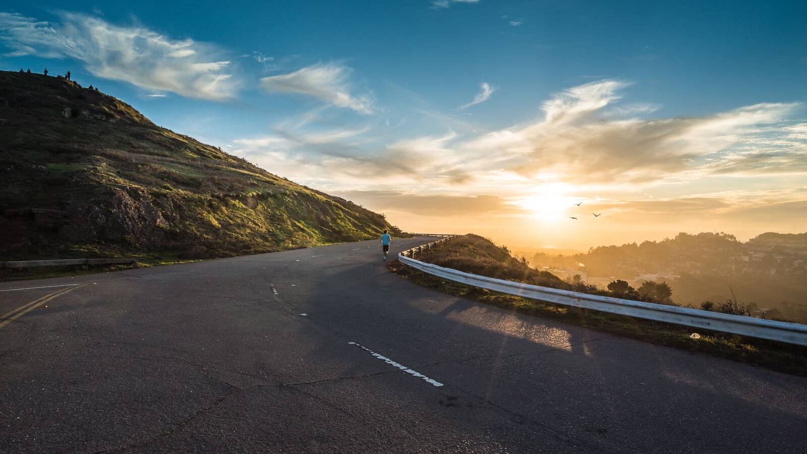 Person running up a hill. Photo by Joshua Sortino on Unsplash.