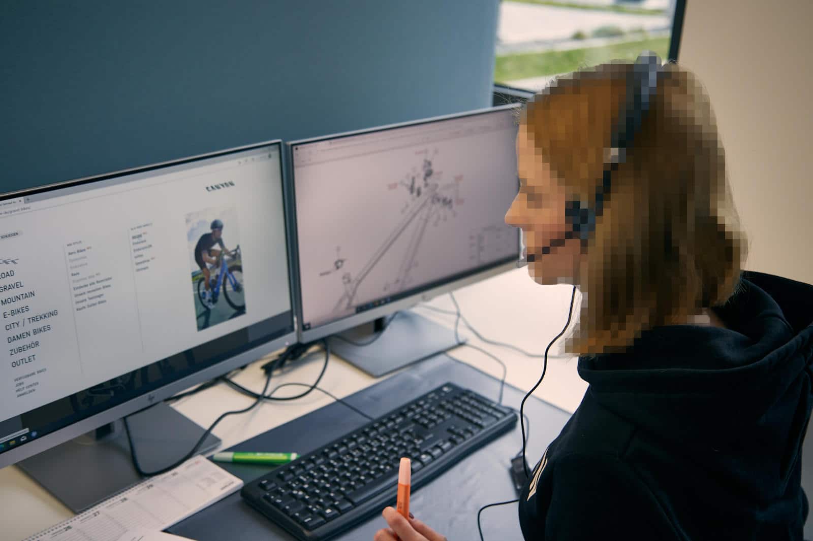 Woman in front if computer workstation showing the canyon website and a parts diagram of canyon bicycle. Author: Simon Simak.