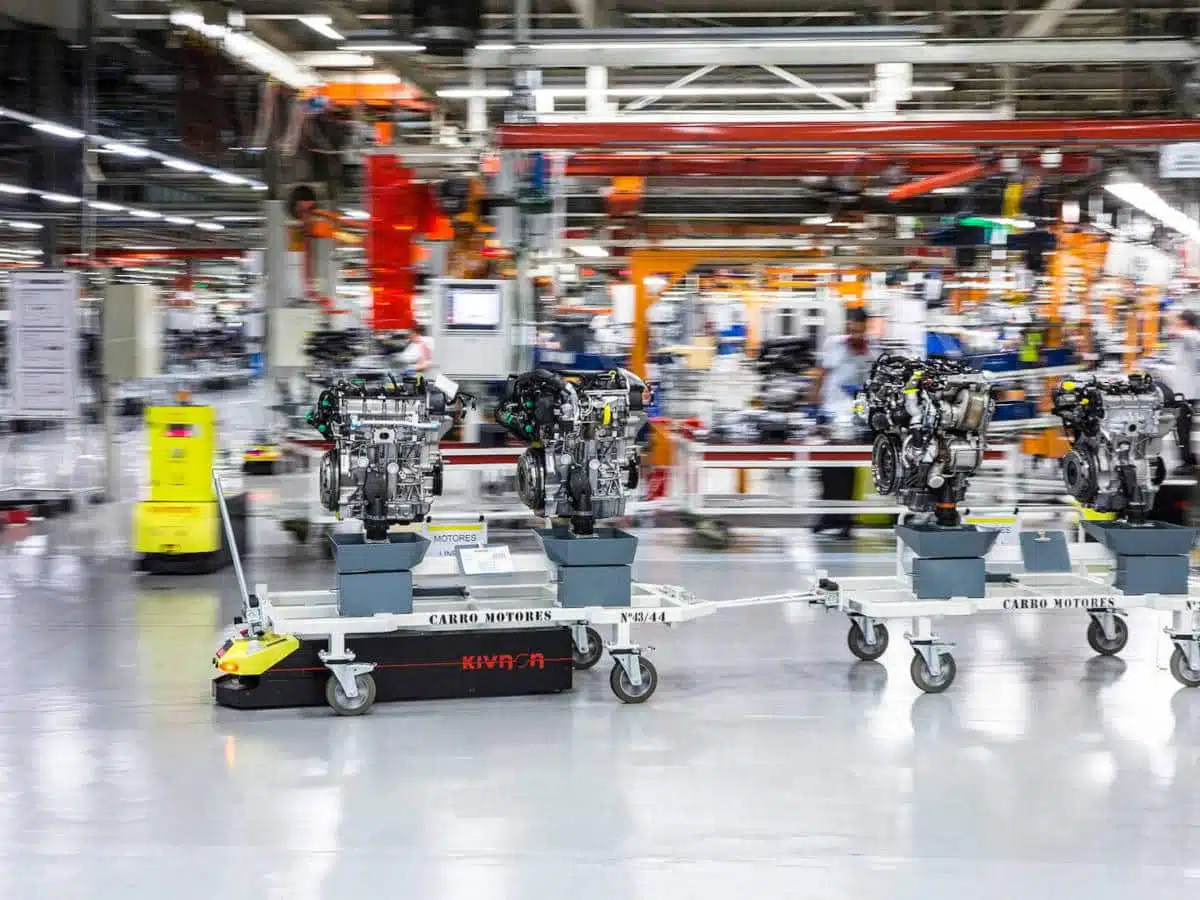 Image of an automated guided vehicle in factory pulling three engine blocks. License: MakoGomez90 (https://commons.wikimedia.org/wiki/File:AGV_con_carro.jpg), „AGV con carro“, https://creativecommons.org/licenses/by-sa/4.0/legalcode