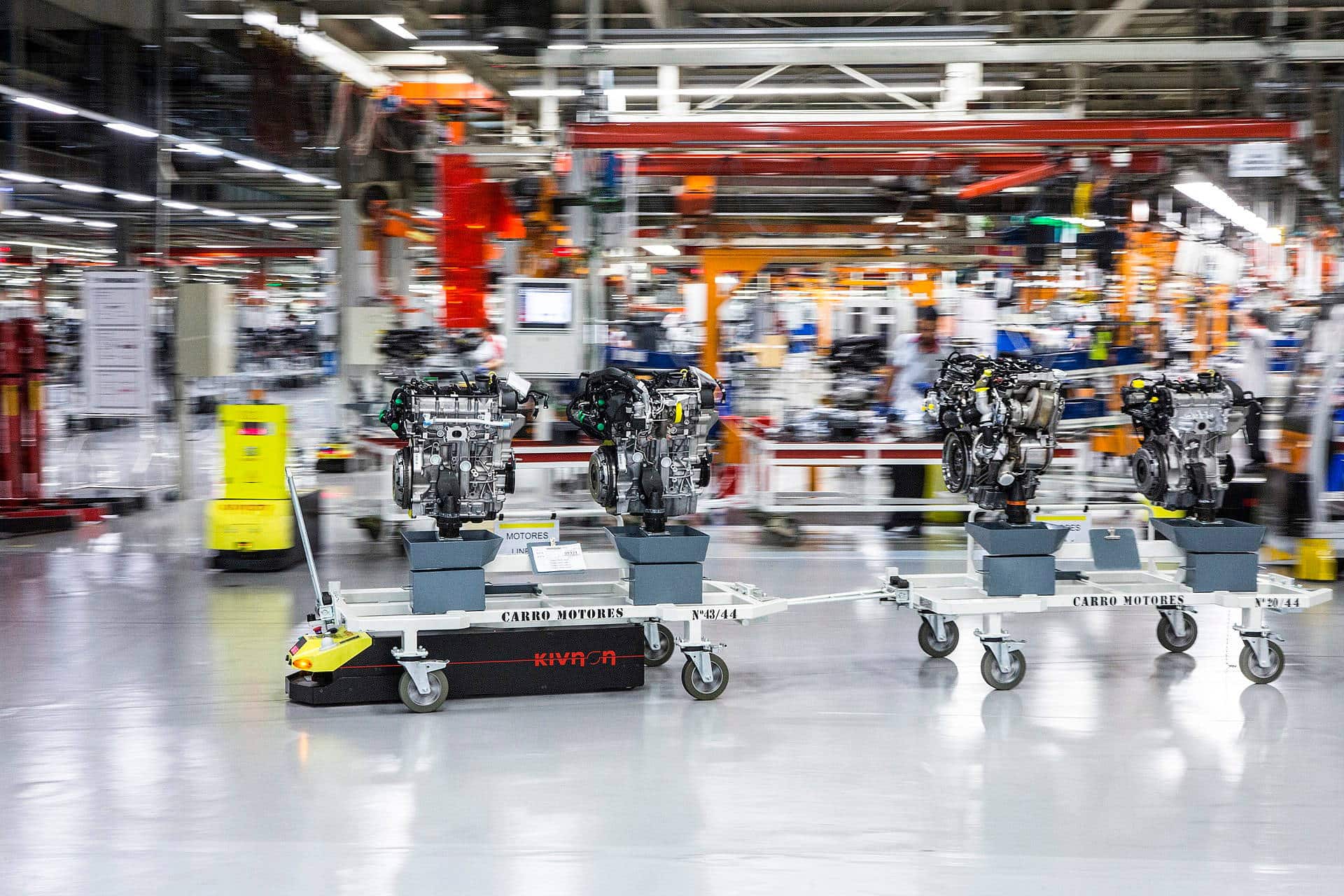 Image of an automated guided vehicle in factory pulling three engine blocks. License: MakoGomez90 (https://commons.wikimedia.org/wiki/File:AGV_con_carro.jpg), „AGV con carro“, https://creativecommons.org/licenses/by-sa/4.0/legalcode