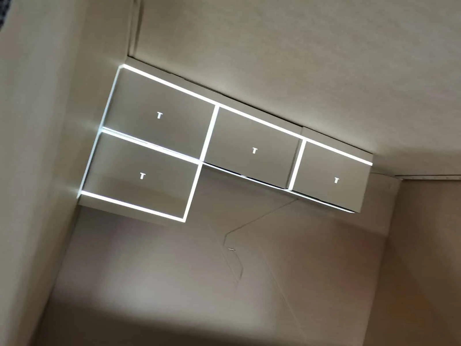 View inside a shipping crate with a light projection outlining the next object to be placed inside it.