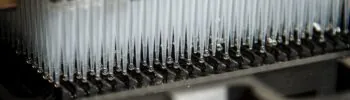 Photo of a gray lab machine with pipettes by National Cancer Institute on Unsplash.