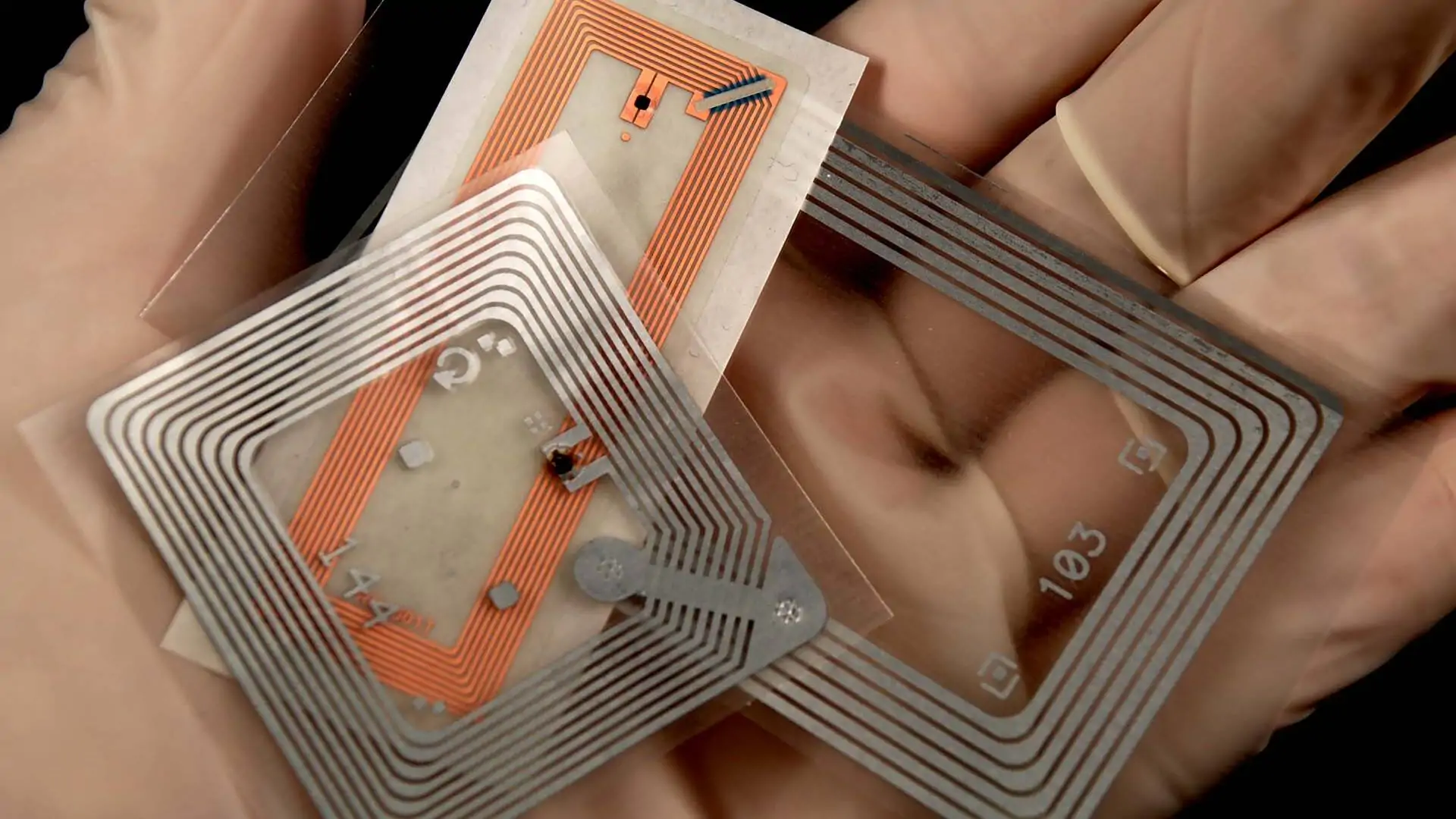 RFID-Chips auf einer mit Gummhandschuhen geschützten Hand - Titelbild RFID-Beitrag