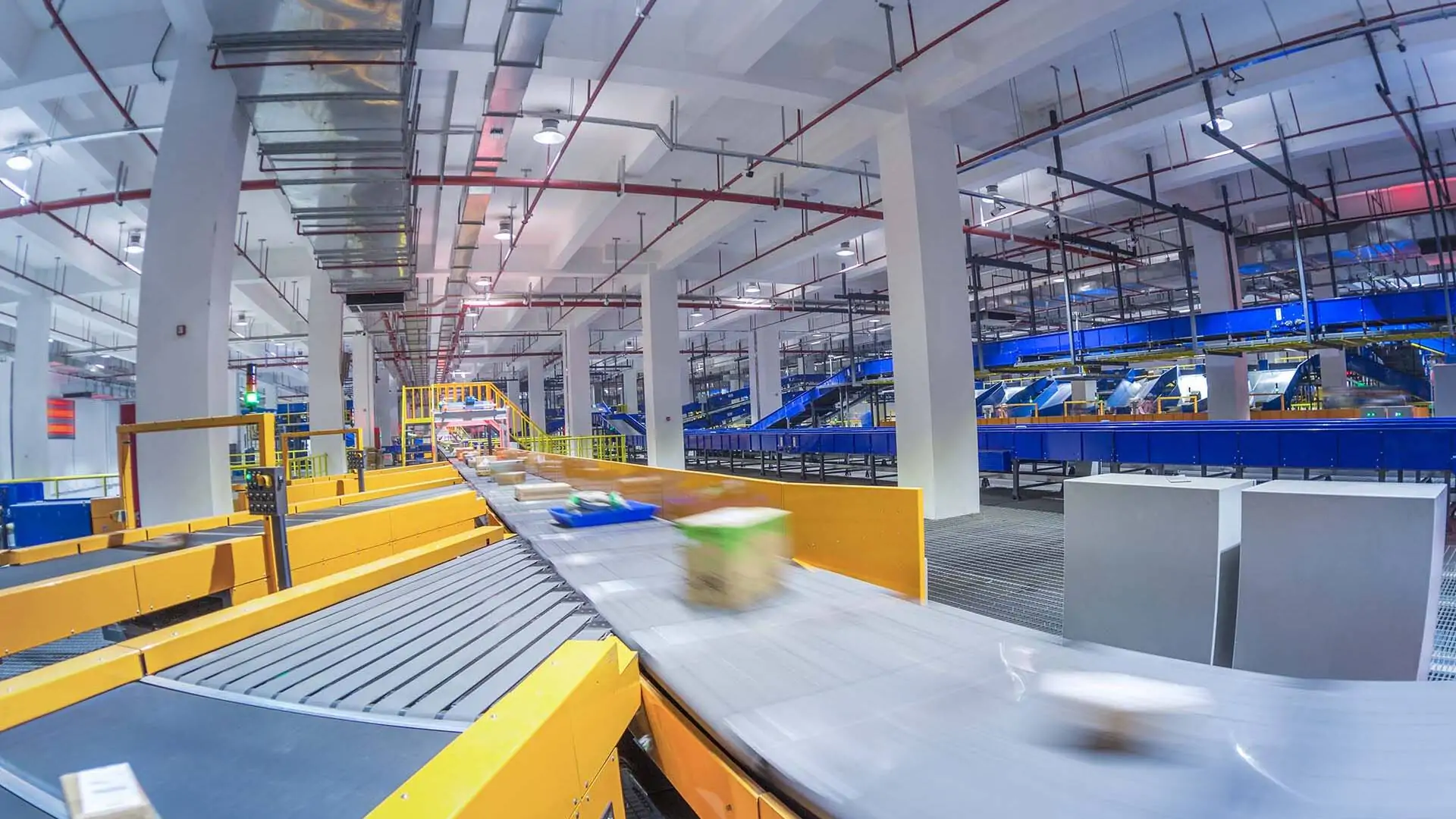 Sortiermaschine an einem Förderband in einem Logistikzentrum - Pakete laufen auf dem Förderband und werden aussortiert