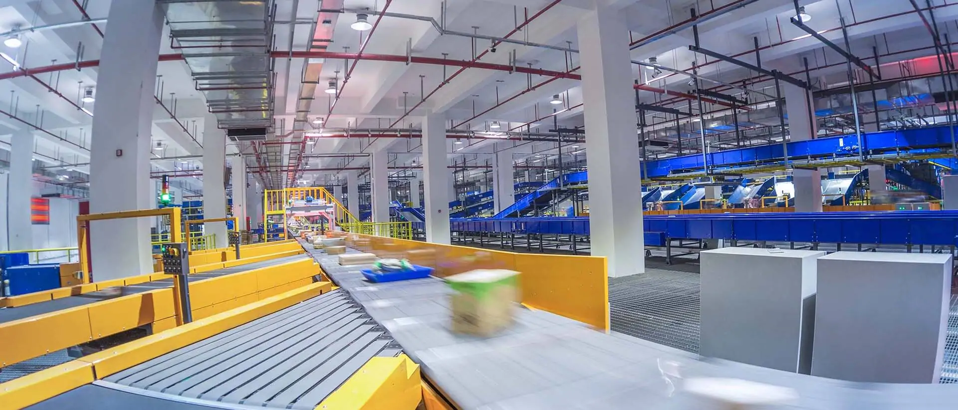 Sortiermaschine an einem Förderband in einem Logistikzentrum - Pakete laufen auf dem Förderband und werden aussortiert