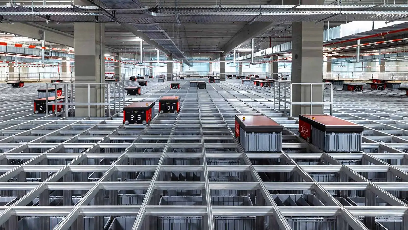 Blick auf die Oberseite einer Cube-Storage-Installation der Marke Autostore mit pickenden Robotern