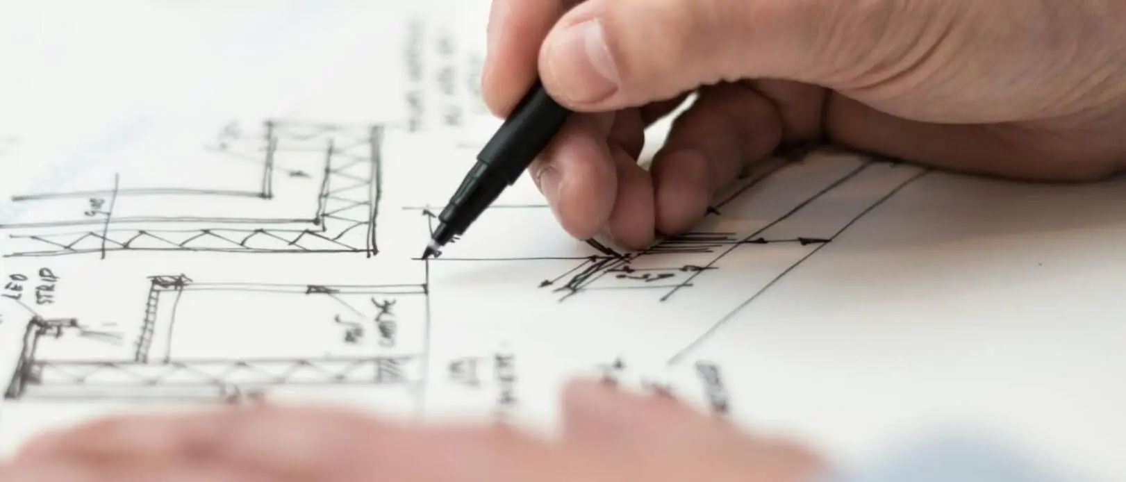Hände mit Stift, zeichnen einen Lageplan