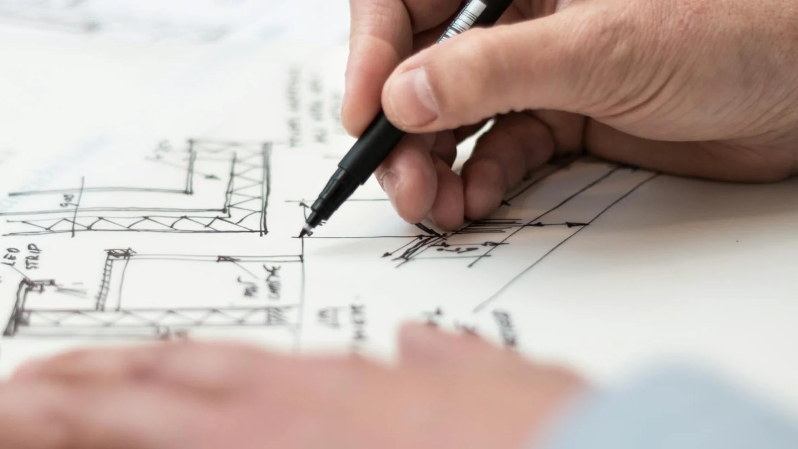 Hände mit Stift, zeichnen einen Lageplan