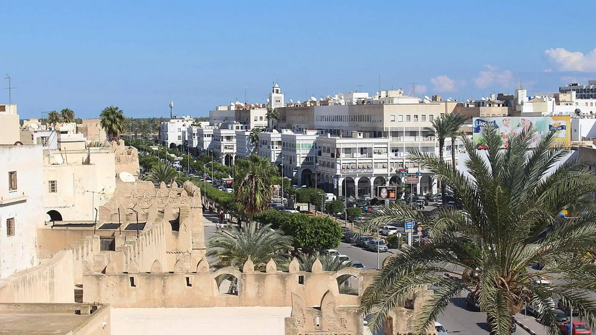Dies ist ein Panoramablick von einem Aussichtsturm auf die Kasbah von Sfax. Von diesem Panoramablick aus kann man die Stadtmauer von Sfax, die Avenue Ali Balhaouane und die Gebäude mit Blick auf die Avenue Ali Balhaouane sehen. Urhebender: Csisc (https://commons.wikimedia.org/wiki/File:Murailles_de_sfax_vue_casbah_sfax_avenue_ali_balhaouane.jpg), „Murailles de sfax vue casbah sfax avenue ali balhaouane“, https://creativecommons.org/licenses/by-sa/4.0/legalcode