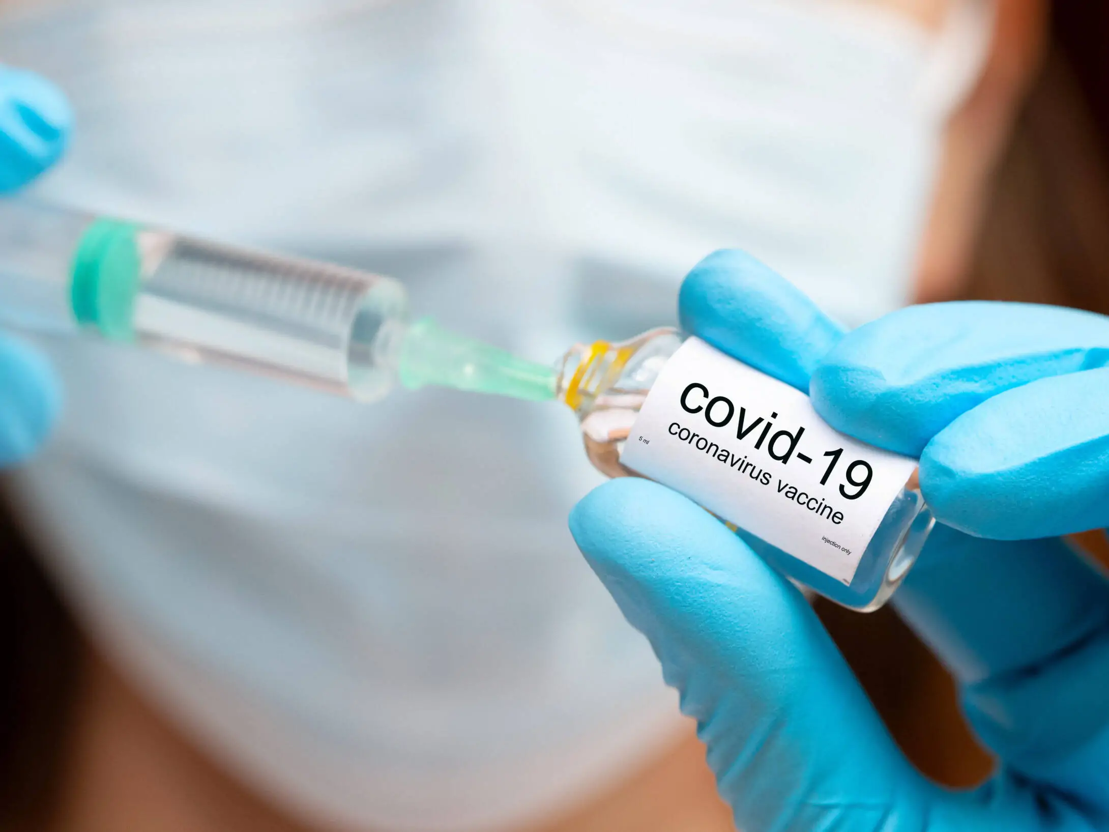 covid vaccine injection, hands in medical gloves with vaccine ampoula and syringe