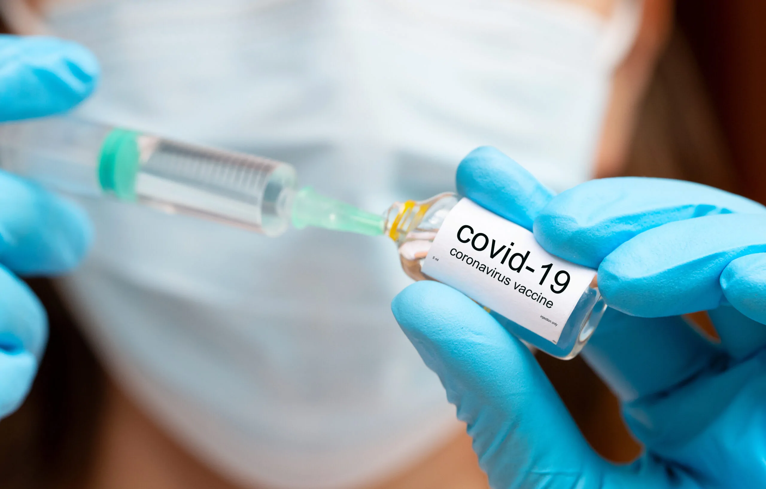 covid vaccine injection, hands in medical gloves with vaccine ampoula and syringe