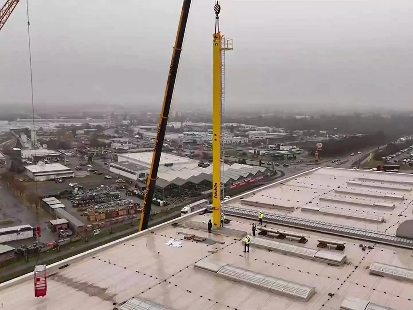 Ein gelbes Regalbediengerät der Stöckling Group wird über eine Dachluke in den Standort Haldensleben der Hermes Fulfillment GmbH eingebracht. Bildrechte