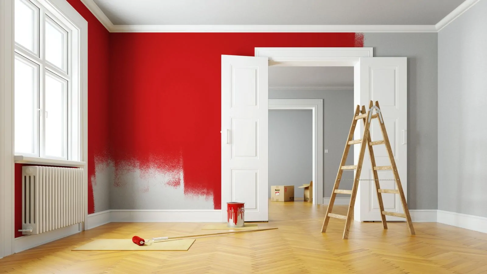 Person streicht eine Wand bei einer Renovierung rot