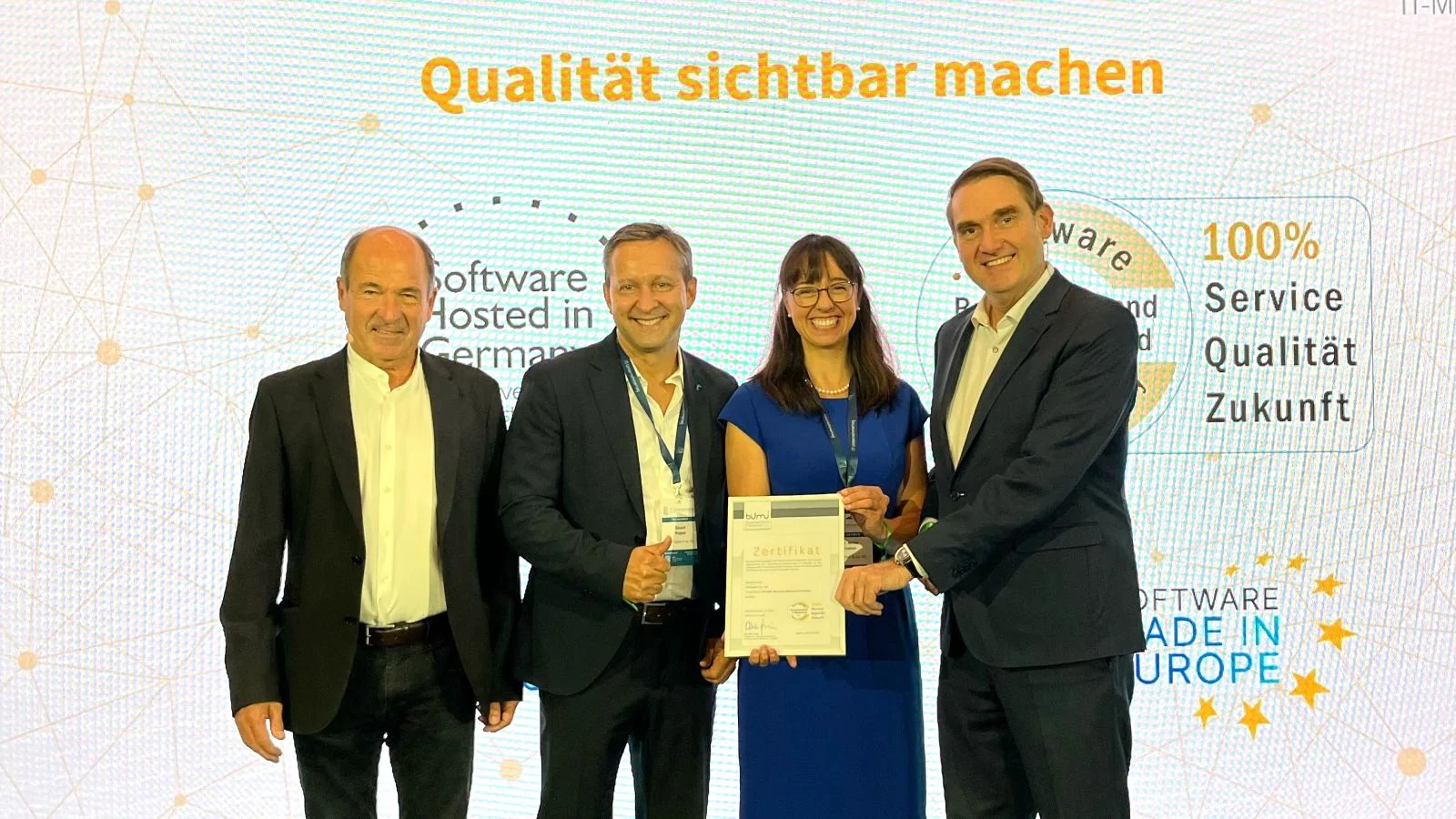 Vier Personen vor digitaler Wand mit Aufschrift 